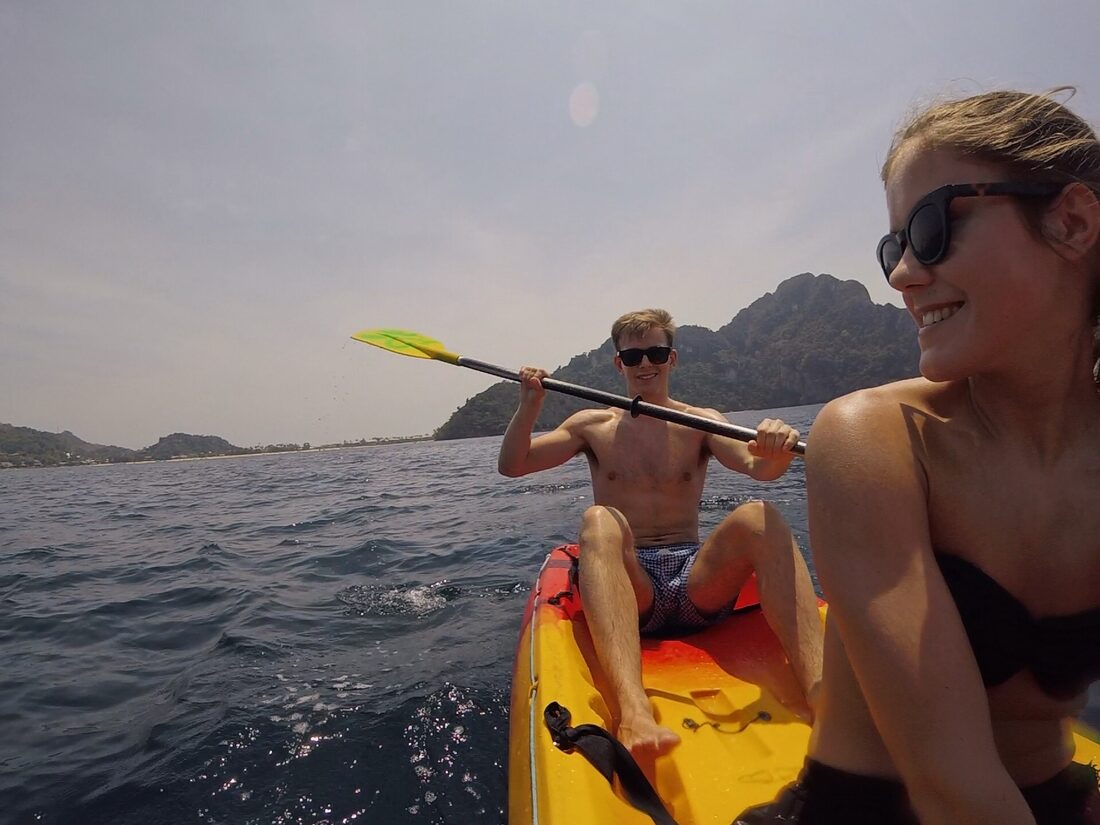 Julie og Sivert i kajakk med fjell i bakgrunnen