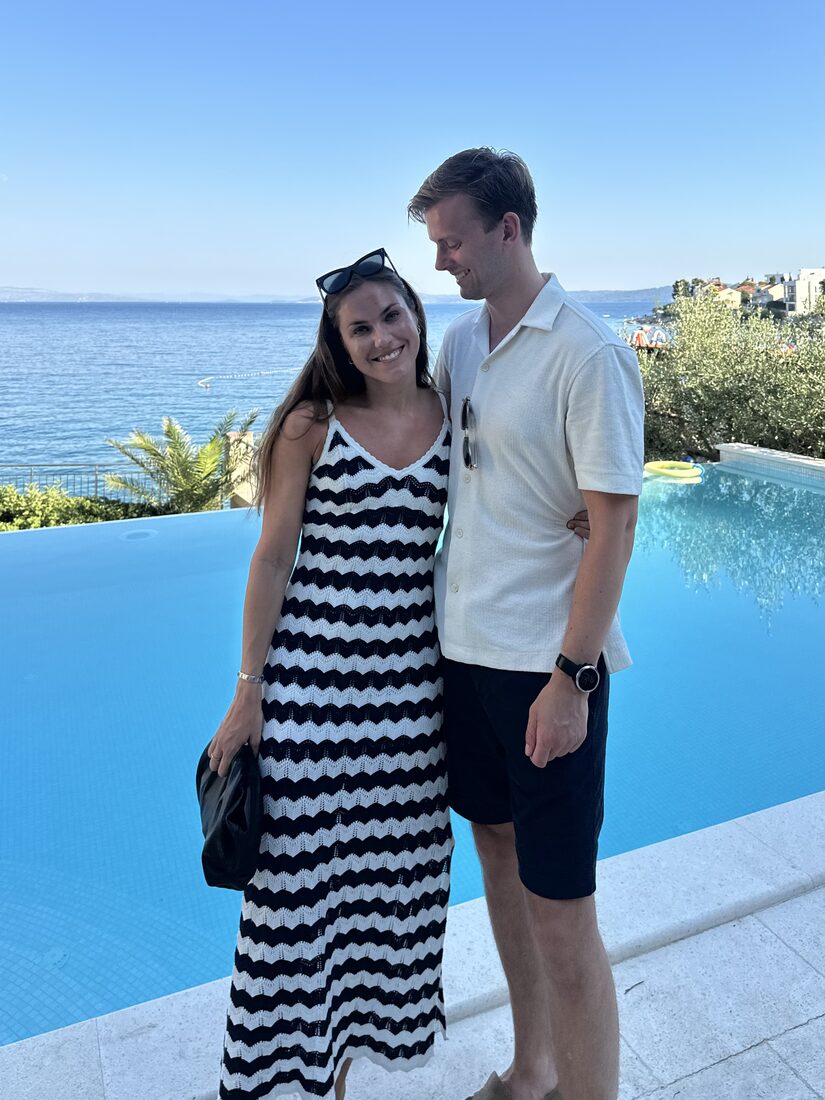 Julie og Sivert ved et basseng med havutsikt