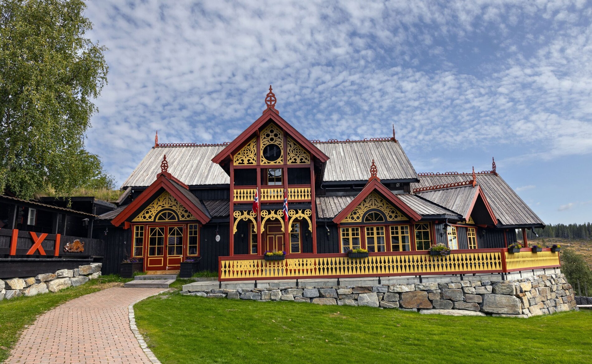 Huso Lodge & Farm sin hovedbygning i dragestil, sort med rødt og gull